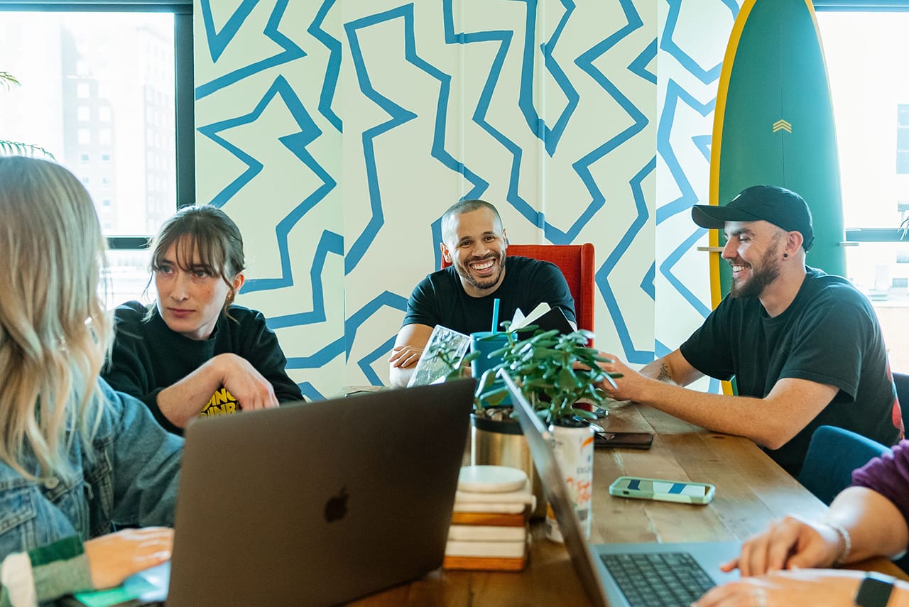 team members in office looking at a tablet